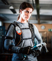 Woman wearing Ironhand Grip-Assist Gloves and holding a tool in her right hand