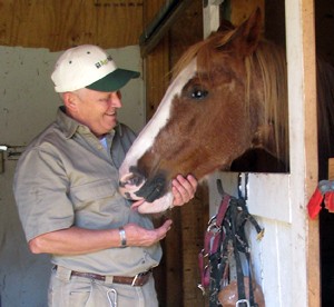 Michael Trost petting horse in stall